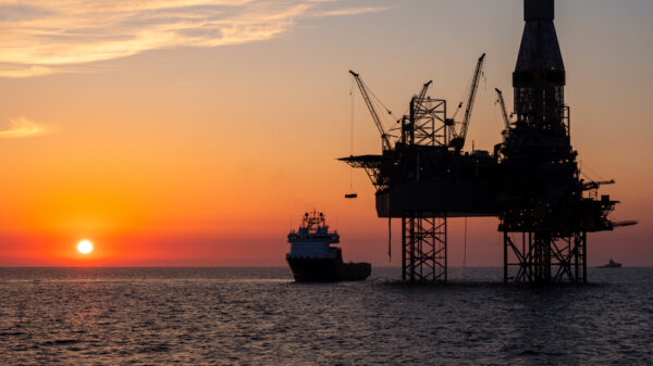Oil platform and a supply vessel in the North sea during sunset.