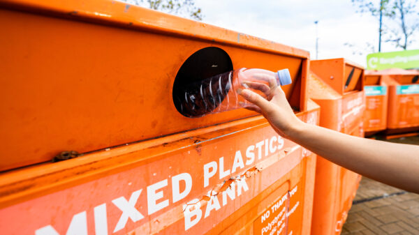 Recycling a plastic bottle at a bottle bank, The deposit return scheme is set to cost retailers £18.8 billion a year from 2025, ten times the amount officials previously claimed.
