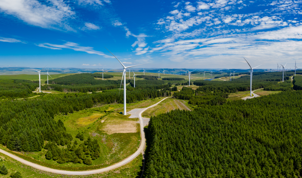 Aerial drone panorama of turbines at a large onshore windfarm in Wales, UK