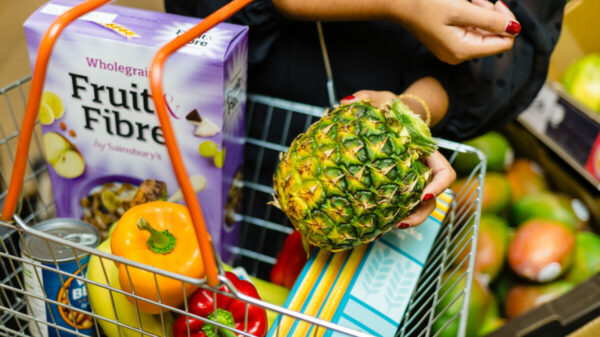 Sainsbury's customer putting crownless pineapple into shopping basket