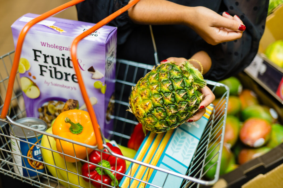 Sainsbury's customer putting crownless pineapple into shopping basket